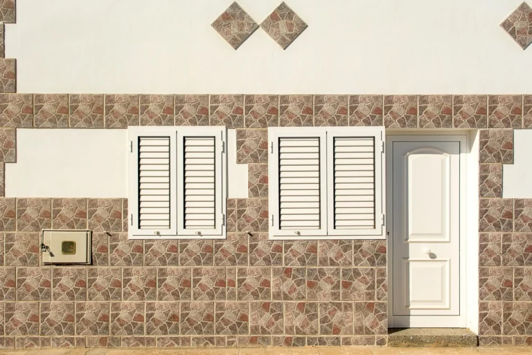 Pergola adossée à lames orientables fixée en façade, avec deux poteaux côté terrasse